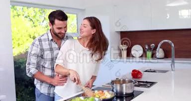 幸福的男人在妻子做饭的时候<strong>伸手接</strong>她